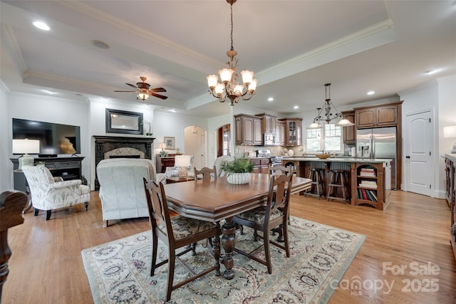 103 3rd St SW, Catawba, NC 28609 - dining space featuring a fireplace, a raised ceiling, ceiling fan, arched walkways, and light wood-style flooring