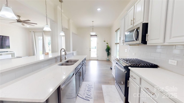 7651 Fenn Way, Fort Mill, SC 29707 - kitchen featuring stainless steel appliances, a sink, light wood finished floors, tasteful backsplash, and white cabinets