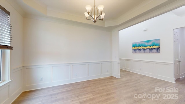 7651 Fenn Way, Fort Mill, SC 29707 - empty room featuring light wood-style floors, a chandelier, a decorative wall, a wainscoted wall, and ornamental molding