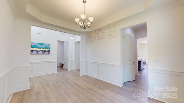 7651 Fenn Way, Fort Mill, SC 29707 - unfurnished room with a chandelier, a decorative wall, wainscoting, a tray ceiling, and light wood-style flooring