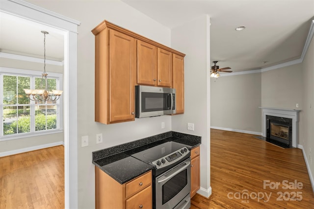 187 Water Oak Dr, Mooresville, NC 28117 - kitchen featuring stainless steel appliances, a chandelier, wood finished floors, a high end fireplace, and crown molding
