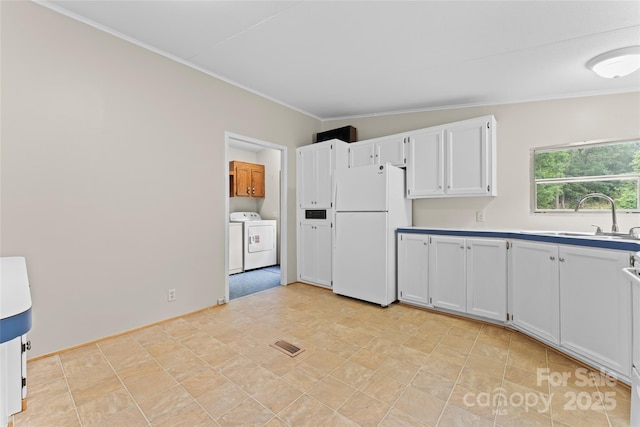 1773 Baldwin Ln, Lincolnton, NC 28092 - kitchen with freestanding refrigerator, independent washer and dryer, crown molding, white cabinets, and light countertops