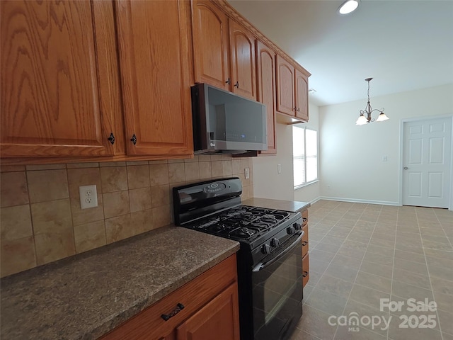 509 Settlers Grove Ln, Salisbury, NC 28146 - kitchen featuring stainless steel microwave, black range with gas cooktop, decorative backsplash, a chandelier, and brown cabinets