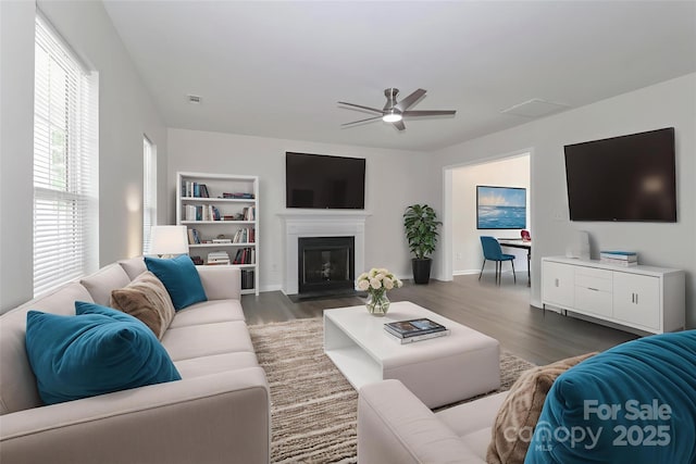 7806 Mcgarry Trl, Charlotte, NC 28214 - living room featuring ceiling fan, dark wood-style floors, a glass covered fireplace, and built in shelves