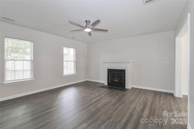 7806 Mcgarry Trl, Charlotte, NC 28214 - unfurnished living room featuring a fireplace with flush hearth, healthy amount of natural light, dark wood-style floors, and ceiling fan