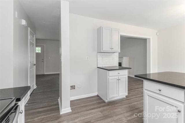 7806 Mcgarry Trl, Charlotte, NC 28214 - kitchen featuring dark countertops, dark wood-style floors, tasteful backsplash, electric stove, and white cabinets
