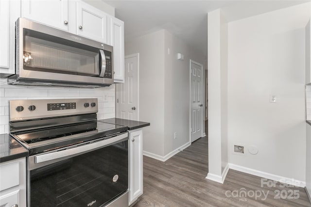 7806 Mcgarry Trl, Charlotte, NC 28214 - kitchen with stainless steel appliances, backsplash, wood finished floors, dark countertops, and white cabinets