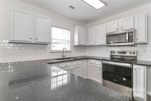 7806 Mcgarry Trl, Charlotte, NC 28214 - kitchen featuring appliances with stainless steel finishes, backsplash, dark stone counters, and white cabinets