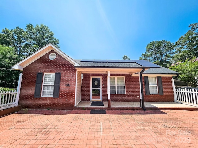 501 N Johnson St, Monroe, NC 28112 - ranch-style home with brick siding, roof mounted solar panels, and a porch
