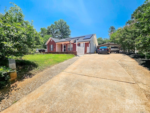 501 N Johnson St, Monroe, NC 28112 - ranch-style home with brick siding, a front yard, driveway, solar panels, and a carport