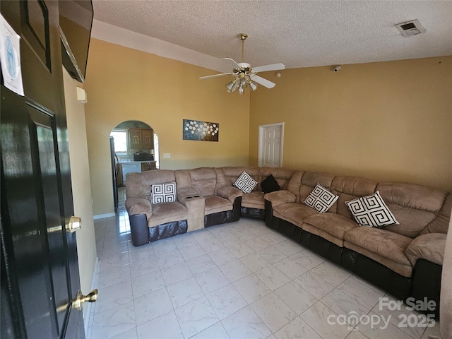 501 N Johnson St, Monroe, NC 28112 - living area featuring a ceiling fan, arched walkways, light marble finish flooring, a textured ceiling, and a high ceiling