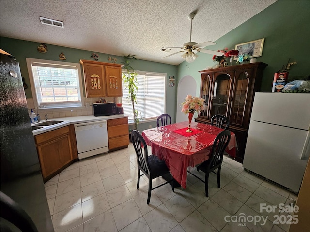 501 N Johnson St, Monroe, NC 28112 - kitchen with white appliances, plenty of natural light, brown cabinetry, and a textured ceiling