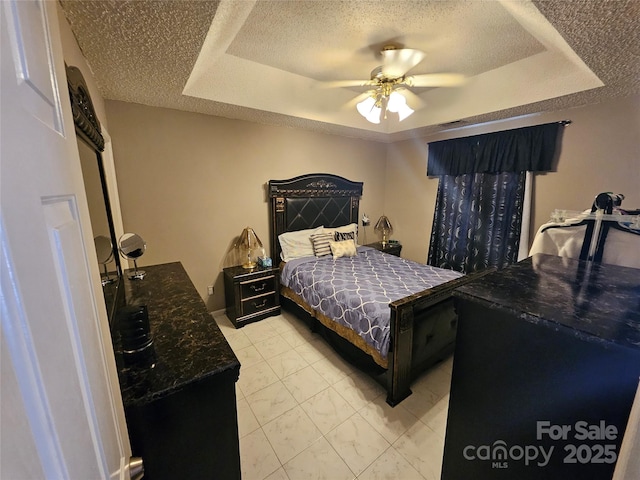 501 N Johnson St, Monroe, NC 28112 - bedroom with a tray ceiling, a textured ceiling, a ceiling fan, and light marble finish flooring