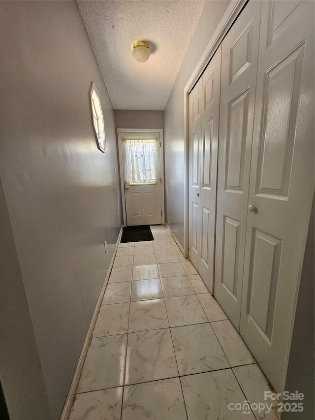 501 N Johnson St, Monroe, NC 28112 - entryway featuring light marble finish floors, baseboards, and a textured ceiling