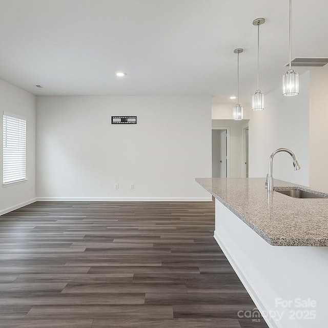 3833 Crossbane St, Kannapolis, NC 28081 - kitchen with a sink, baseboards, dark wood-style flooring, light stone counters, and recessed lighting