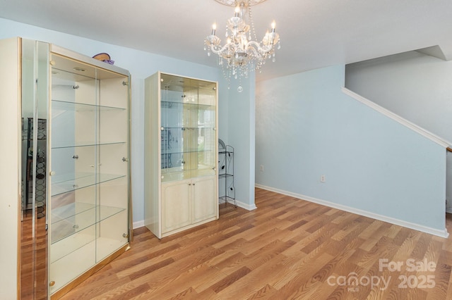 10816 Pointer Ridge Dr, Charlotte, NC 28214 - unfurnished dining area with light wood-type flooring, a chandelier, and baseboards