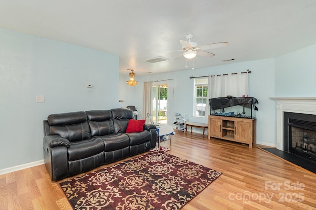 10816 Pointer Ridge Dr, Charlotte, NC 28214 - living area featuring ceiling fan, light wood-style flooring, a fireplace, and baseboards
