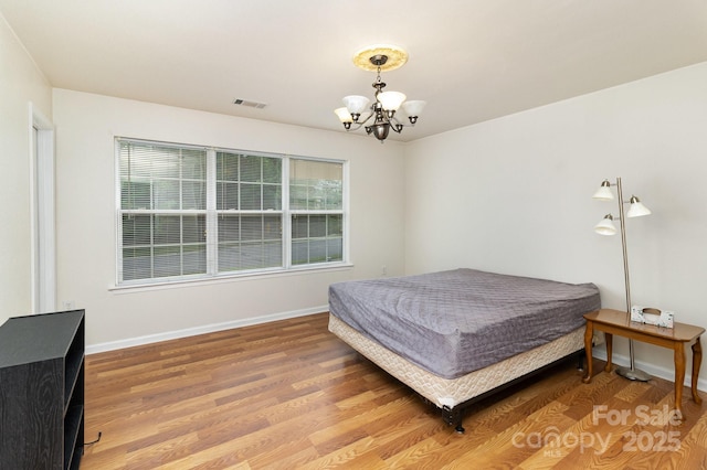 10816 Pointer Ridge Dr, Charlotte, NC 28214 - bedroom featuring a chandelier, light wood finished floors, and baseboards