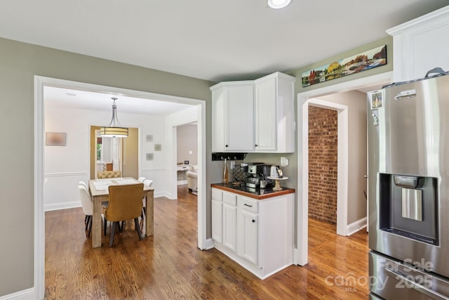 10311 Windtree Ln, Charlotte, NC 28215 - kitchen with stainless steel refrigerator with ice dispenser, white cabinets, wood finished floors, and baseboards