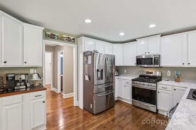 10311 Windtree Ln, Charlotte, NC 28215 - kitchen with stainless steel appliances, dark wood finished floors, white cabinetry, recessed lighting, and baseboards