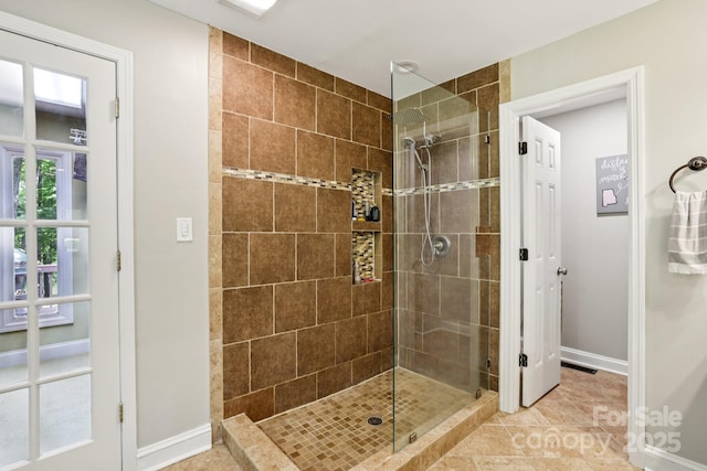 10311 Windtree Ln, Charlotte, NC 28215 - bathroom with a tile shower, baseboards, and tile patterned floors