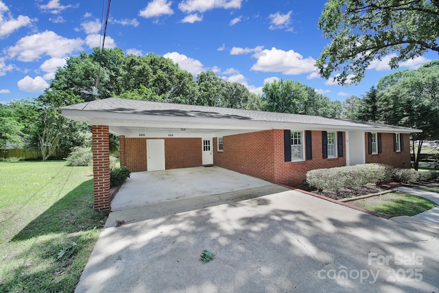 967 Hilldale Dr, Lancaster, SC 29720 - ranch-style home featuring brick siding, a front yard, driveway, an attached carport, and view of scattered trees