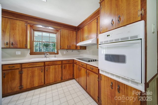 967 Hilldale Dr, Lancaster, SC 29720 - kitchen with a sink, white oven, under cabinet range hood, black electric cooktop, and brown cabinets