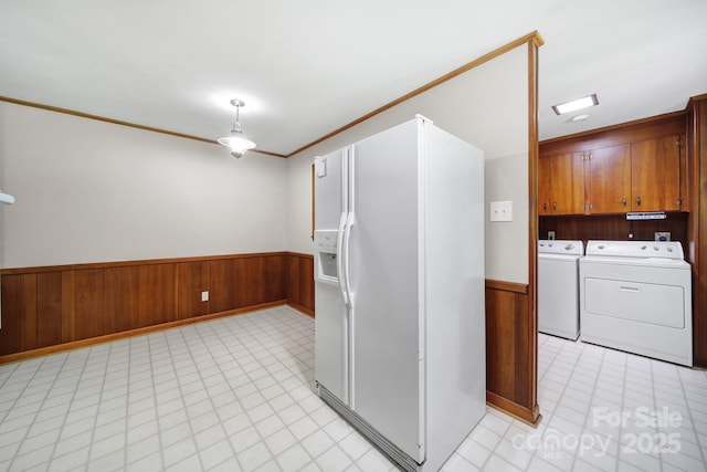 967 Hilldale Dr, Lancaster, SC 29720 - kitchen featuring white refrigerator with ice dispenser, a wainscoted wall, brown cabinets, wooden walls, and washing machine and clothes dryer