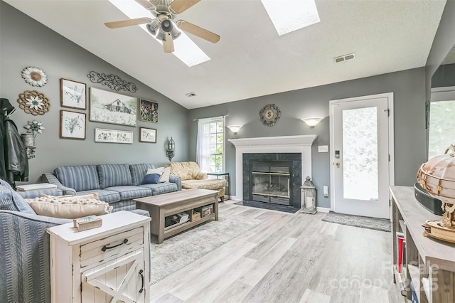 60 Southchase Dr, Fletcher, NC 28732 - living area featuring vaulted ceiling, light wood-style floors, a skylight, a ceiling fan, and a fireplace
