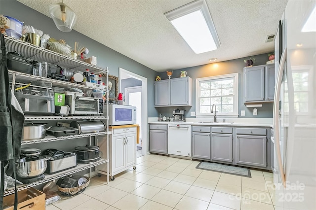 60 Southchase Dr, Fletcher, NC 28732 - kitchen featuring white appliances, gray cabinets, a sink, a textured ceiling, and light countertops