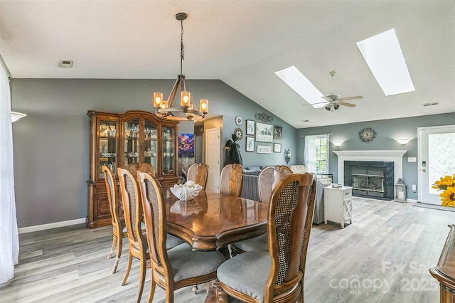 60 Southchase Dr, Fletcher, NC 28732 - dining area featuring light wood-style floors, a skylight, vaulted ceiling, a premium fireplace, and a chandelier