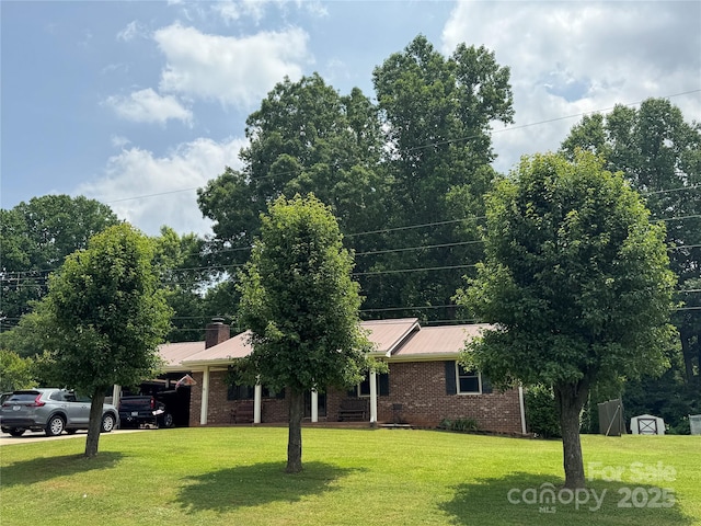 136 Christopher Rd, Marion, NC 28752 - view of front of home with brick siding, a front yard, a metal roof, and a chimney