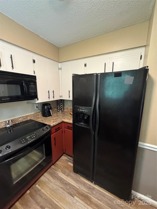136 Christopher Rd, Marion, NC 28752 - kitchen featuring black appliances, light wood finished floors, a textured ceiling, and white cabinets