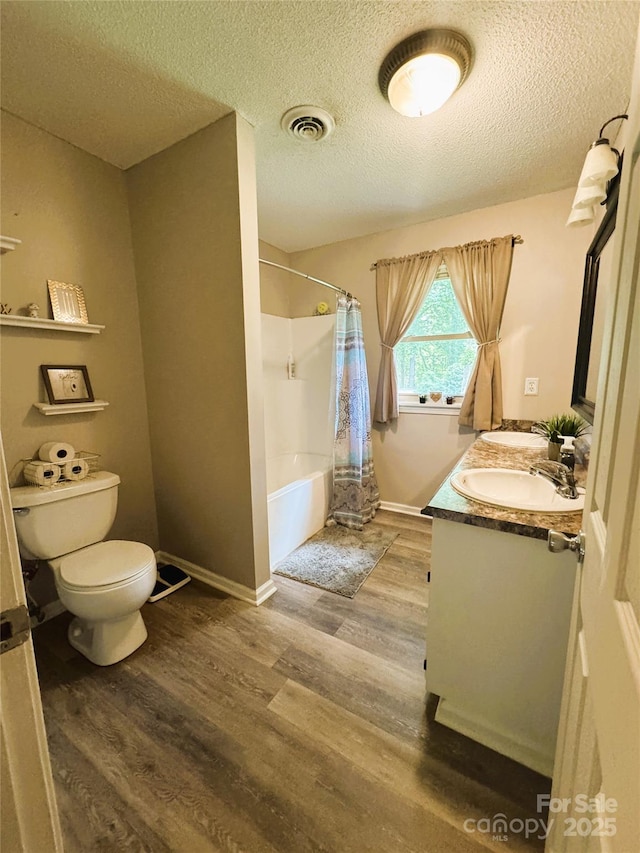 136 Christopher Rd, Marion, NC 28752 - full bath featuring double vanity, wood finished floors, a textured ceiling, and shower / bath combo with shower curtain