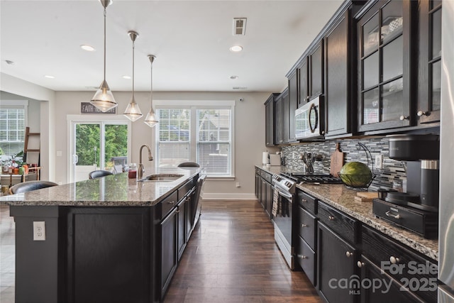 10012 Michael Crossing Dr, Charlotte, NC 28213 - kitchen with a sink, stainless steel appliances, decorative backsplash, dark stone counters, and dark wood-style floors