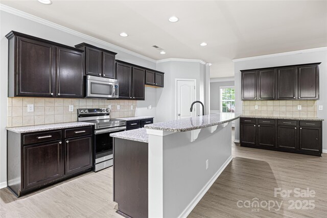 8400 Empress Ct, Charlotte, NC 28227 - kitchen with stainless steel appliances, light wood-type flooring, ornamental molding, light stone countertops, and backsplash