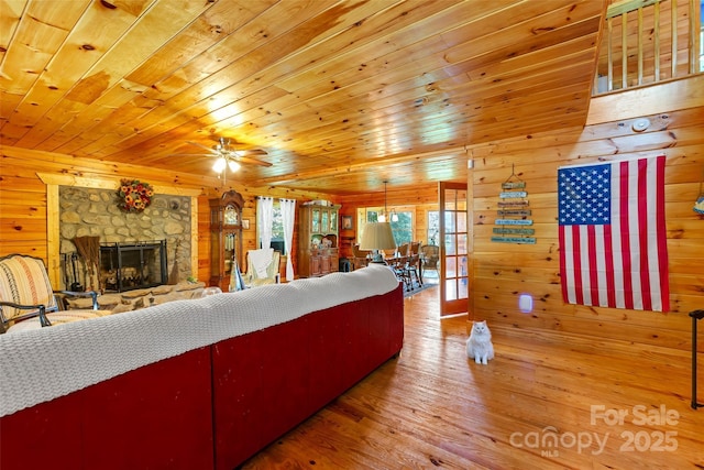 252 Idylwild Ln, Black Mountain, NC 28711 - living area featuring wooden walls, wooden ceiling, wood-type flooring, ceiling fan, and a stone fireplace