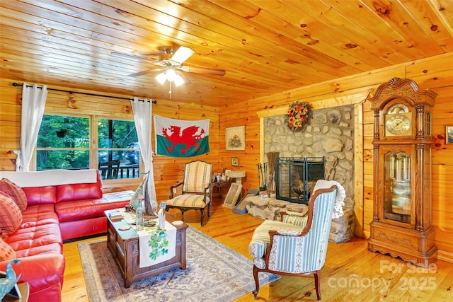 252 Idylwild Ln, Black Mountain, NC 28711 - living room with wooden ceiling, wood walls, a stone fireplace, wood-type flooring, and ceiling fan