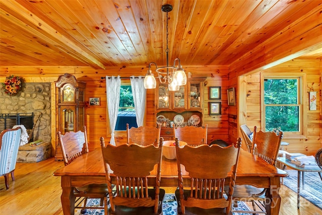 252 Idylwild Ln, Black Mountain, NC 28711 - dining space featuring light wood finished floors, wood ceiling, wooden walls, a chandelier, and a fireplace