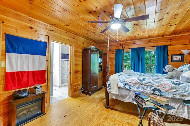 252 Idylwild Ln, Black Mountain, NC 28711 - bedroom featuring wooden ceiling, wood-type flooring, wood walls, and a glass covered fireplace