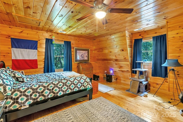 252 Idylwild Ln, Black Mountain, NC 28711 - bedroom with wood ceiling, multiple windows, wood walls, wood finished floors, and a wood stove
