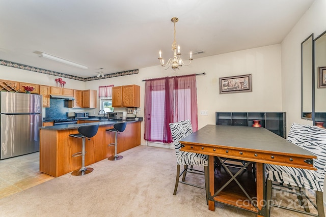 1825 Stroud Park Ct, Charlotte, NC 28206 - kitchen featuring stainless steel appliances, a chandelier, dark countertops, brown cabinets, and a peninsula