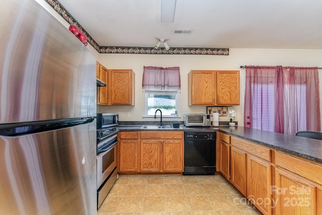 1825 Stroud Park Ct, Charlotte, NC 28206 - kitchen featuring appliances with stainless steel finishes, a sink, dark countertops, and brown cabinetry