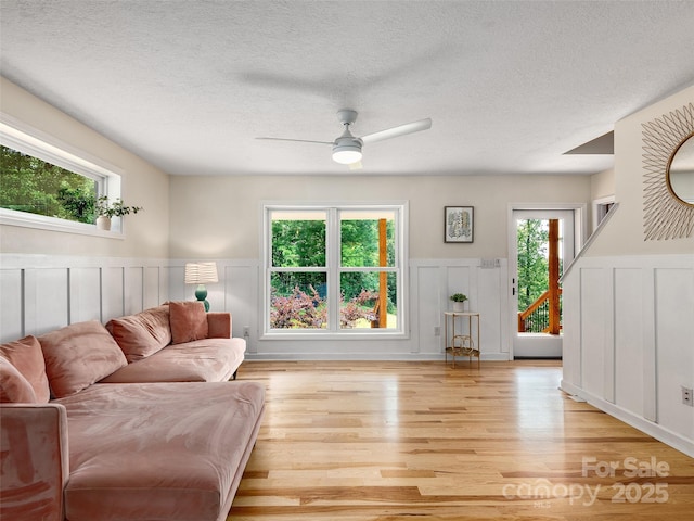 31 Rory Phillips Vw, Candler, NC 28715 - living area featuring a decorative wall, a wainscoted wall, a ceiling fan, light wood-type flooring, and a textured ceiling