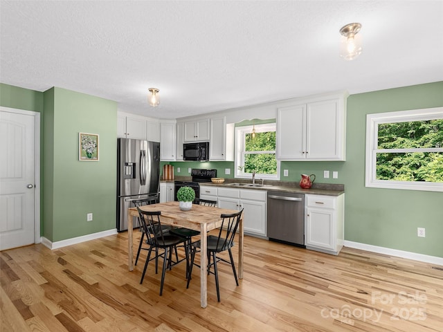 31 Rory Phillips Vw, Candler, NC 28715 - kitchen with black appliances, a sink, light wood-style floors, white cabinets, and a textured ceiling