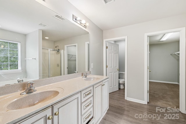 5002 Abode Lily Ln, Charlotte, NC 28227 - full bathroom with a walk in closet, a stall shower, double vanity, and wood finished floors