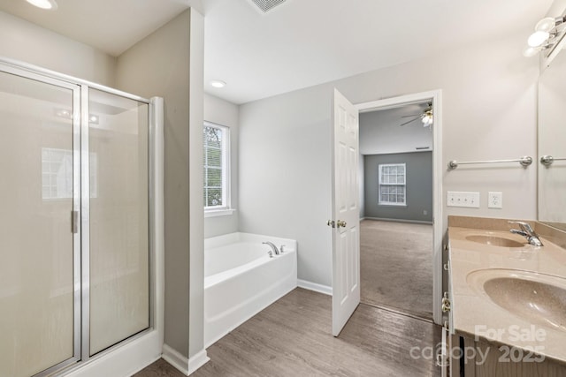 5002 Abode Lily Ln, Charlotte, NC 28227 - bathroom featuring a shower stall, a bath, double vanity, and wood finished floors