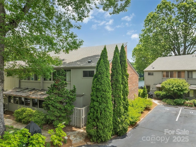 55 Toxaway Shrs Unit 14, Lake Toxaway, NC 28747 - view of property exterior with roof with shingles and uncovered parking
