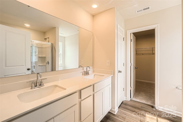 2118 Columbidae Ln, Gastonia, NC 28052 - bathroom featuring wood finished floors, a stall shower, double vanity, a spacious closet, and recessed lighting