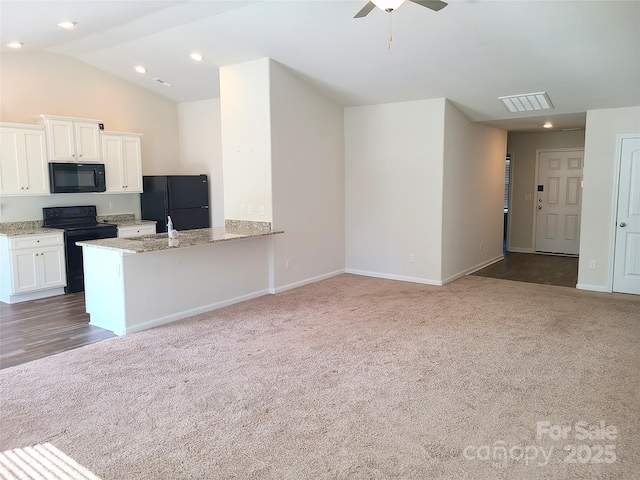 1195 Winding Creek Rd, Salisbury, NC 28146 - kitchen featuring black appliances, carpet floors, light stone countertops, white cabinetry, and lofted ceiling